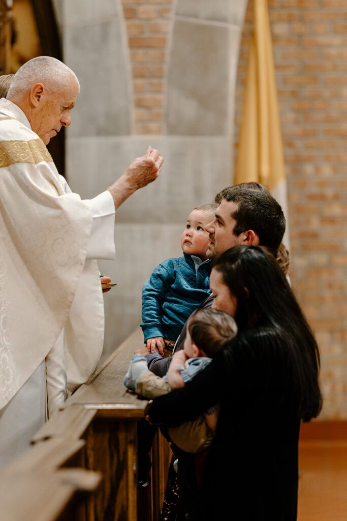 A priest blessing a family